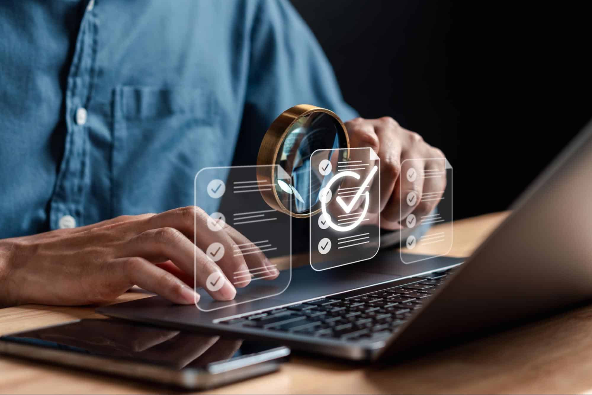 a person looking at a laptop with a magnifying glass